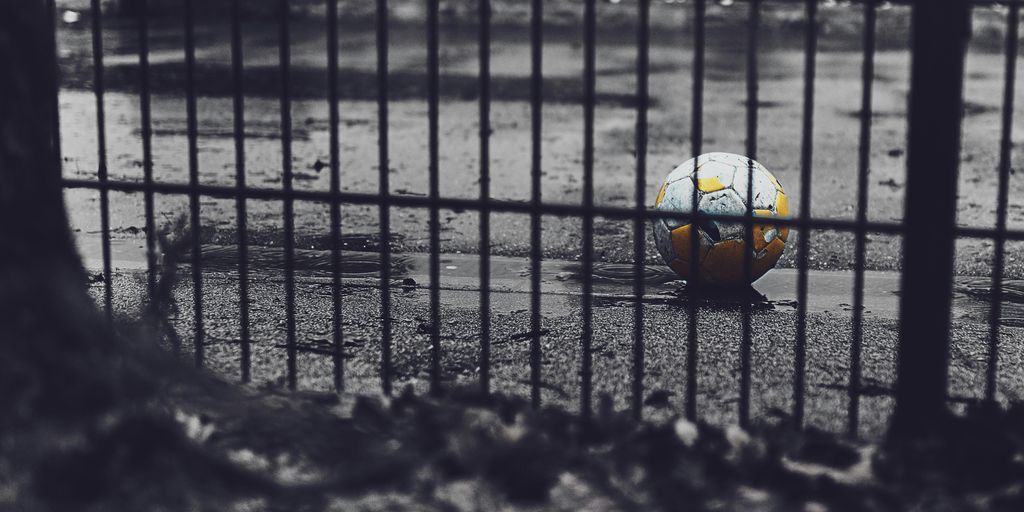 orange and green soccer ball on road