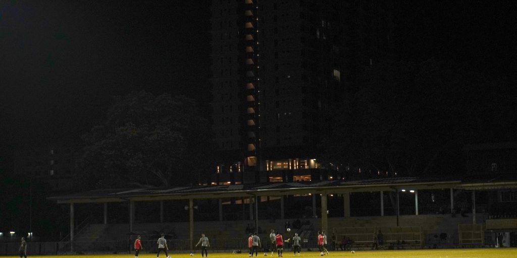 a group of people standing on top of a soccer field