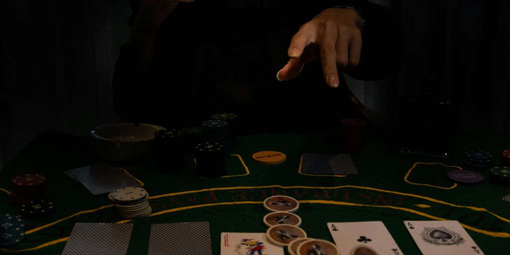 a person sitting at a table with cards and chips