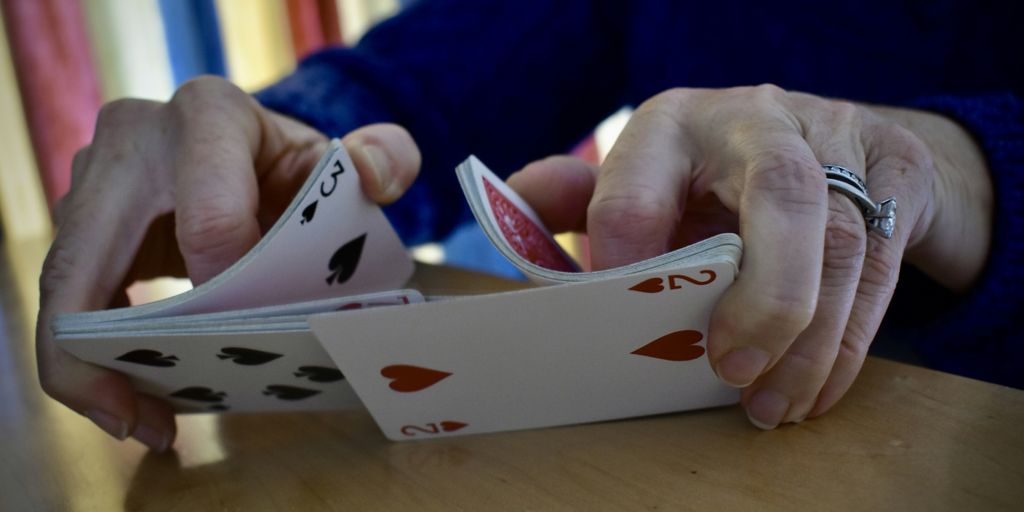 a person is playing cards on a table