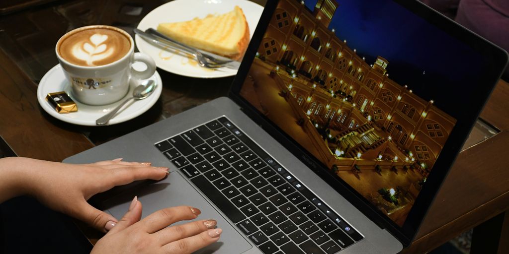 person using macbook pro on table